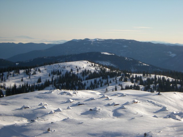 Na vrhu Velike planine pogled na pastirske stane v ozadju  Menina planina in Kašni vrh