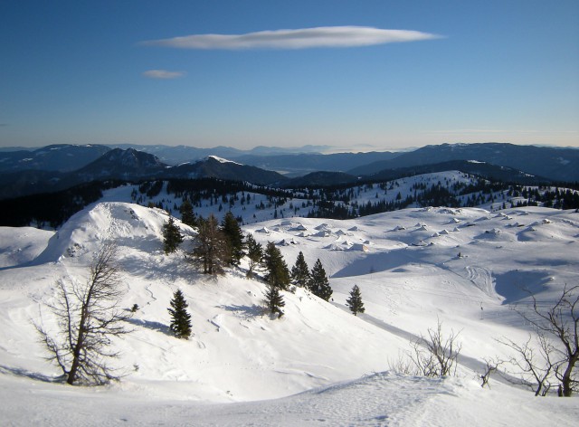 Na vrhu Velike planine pogled na pastirske stane v ozadju Golte, Rogatec, Lepenatka, Menin