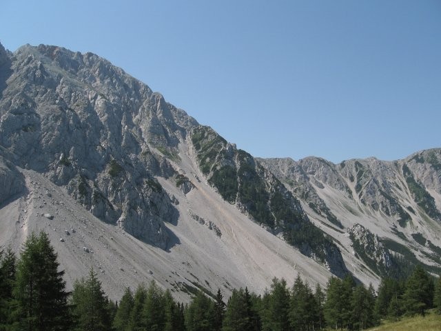 Stolov poraščen stranski greben čez katerega je speljana ferrata
