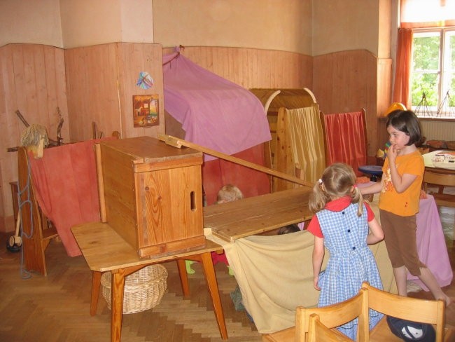 Otroci si zgradijo iz lesenih škatelj, desk in odej različne strukture. Pri tem početju ug